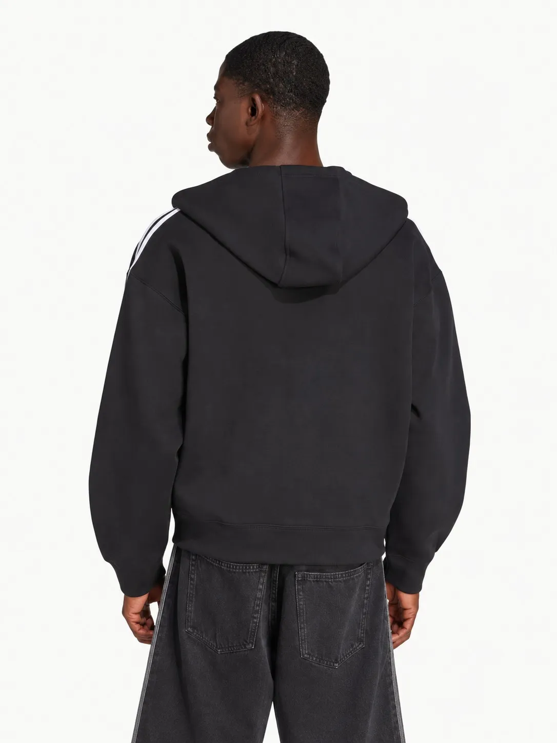 Hoodie Adidas negro puesto, vista de espalda lisa con la capucha caída y las rayas blancas en el hombro